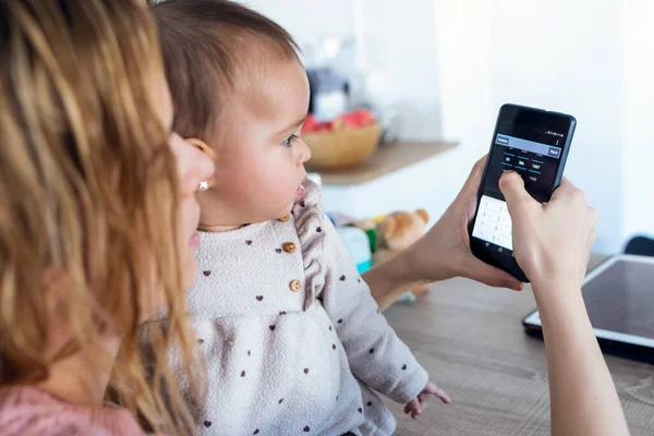 Detailní Záběr Mladé Ženy Pomocí Mobilního Telefonu Zatímco Její Holčička — Stock fotografie