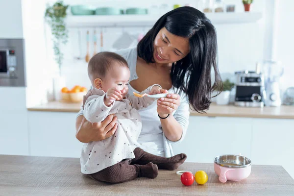 Tiro Feliz Madre Joven Alimentando Linda Niña Con Gachas Frutas —  Fotos de Stock