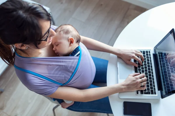 Shot Pretty Young Mother Her Baby Sling Working Laptop Home — Stock Photo, Image