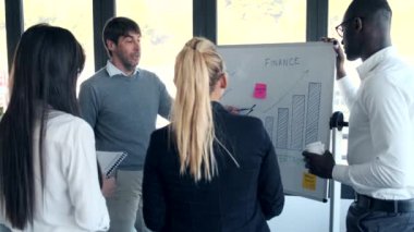 Yakışıklı iş adamı, birlikte çalışma alanındaki meslektaşlarına projeyi anlatıyor..