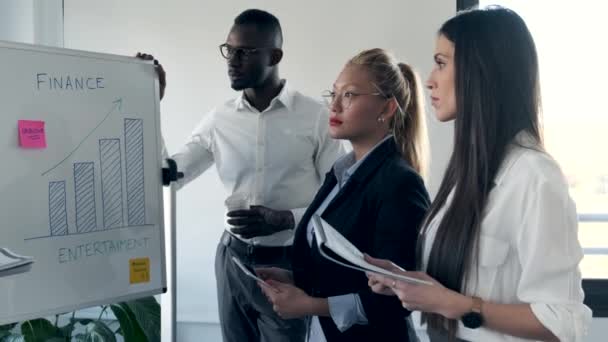 Beau businessman expliquant le projet à ses collègues sur le lieu de coworking . — Video