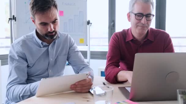 Відео Двох Бізнесменів Які Працюють Своїм Ноутбуком Цифровим Планшетом Сидячи — стокове відео