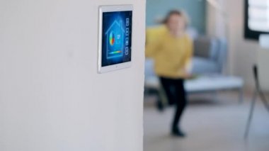 Kanepede oturan küçük kızın videosu kalkıyor ve ev domotik sistemini kullanıyor..