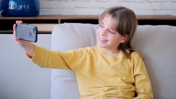 Vídeo Uma Menina Tirando Uma Selfie Com Smartphone Enquanto Senta — Vídeo de Stock