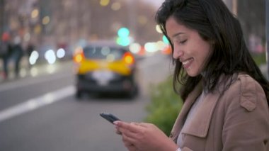 Geceleri yol kenarından alınmayı beklerken cep telefonuyla mesajlaşan güzel bir genç kadının videosu..