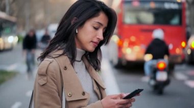 Yolun kenarında beklerken cep telefonuyla mesajlaşan güzel bir genç kadının videosu..