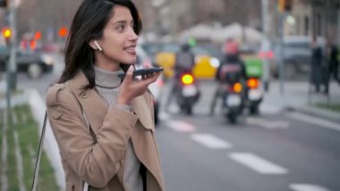 Güzel genç bir bayanın sokakta dururken cep telefonuyla elsiz konuşmasının videosu..