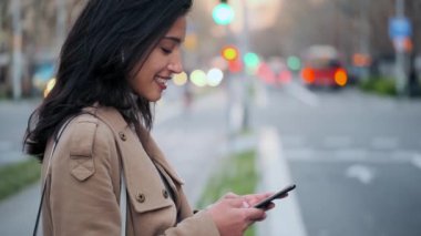 Yolun kenarında beklerken cep telefonuyla mesajlaşan güzel bir genç kadının videosu..