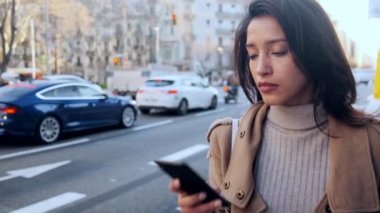 Yolun kenarından alınmayı beklerken cep telefonuyla mesajlaşan güzel bir genç kadının videosu..