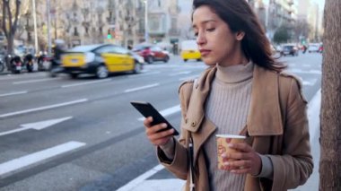 Yolun kenarından alınmayı beklerken cep telefonuyla mesajlaşan güzel bir genç kadının videosu..