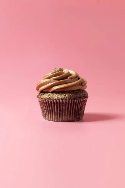 ピンクの背景から隔離された低視点からの豪華なチョコレートカップケーキのショット — ストック写真