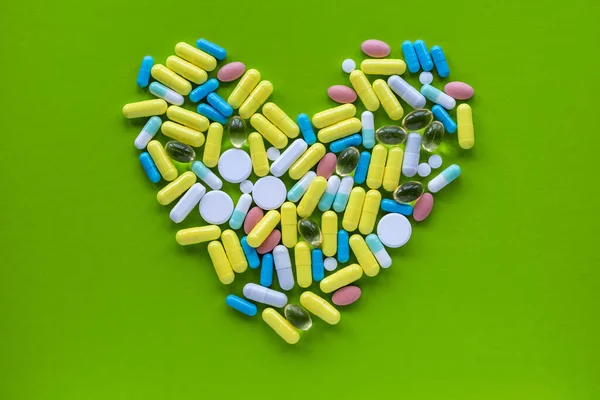 Prise Vue Coeur Faite Pilules Colorées Sur Fond Vert Concept — Photo
