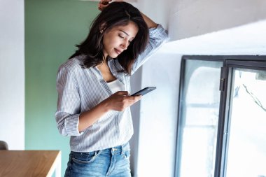 Ofiste beklerken genç ve zarif bir iş kadınının telefon mesajı göndermesi..