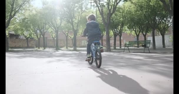 Movimiento Lento Desde Detrás Niño Que Monta Bicicleta Una Calle — Vídeo de stock