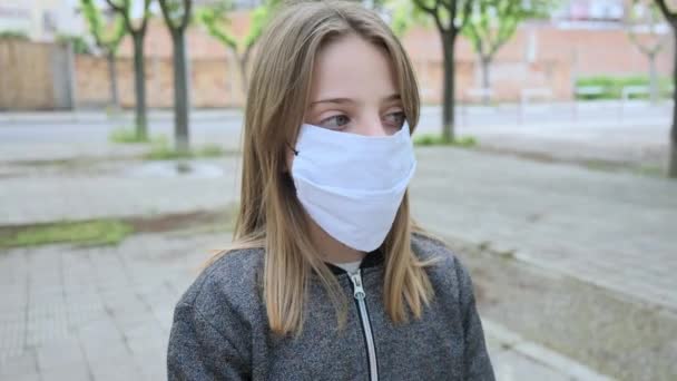 通りを見ながら保護顔のマスクをした子供のクローズアップ — ストック動画