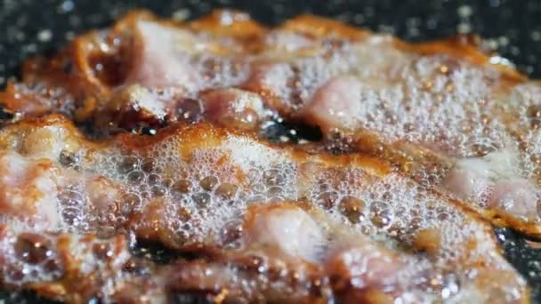 Gros plan d'un bacon frit sur le gril — Video