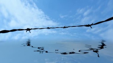 Eski dikenli tel çit yansıma su