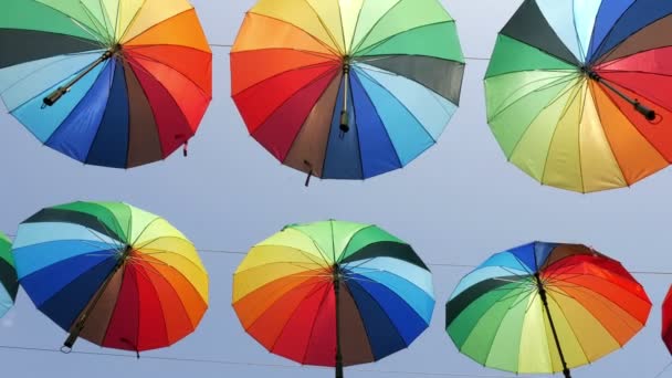Цветные зонтики против голубого неба — стоковое видео