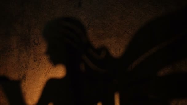 Σκιά αγγέλου φωτισμένη από κερί σε φόντο grunge — Αρχείο Βίντεο