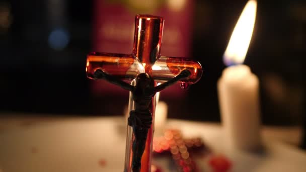 Gros plan de la croix de Jésus avec du sang allumé par une bougie