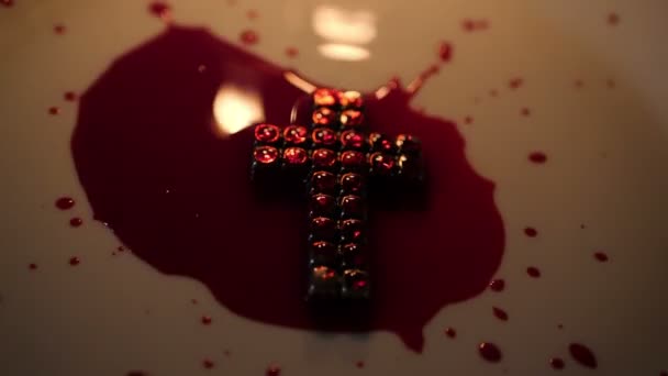 Закрыть крест Иисуса кровью, зажжённой свечой — стоковое видео