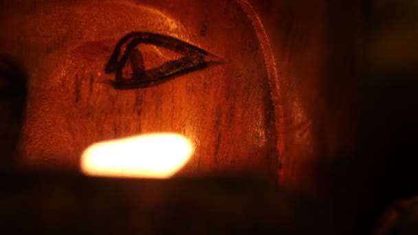 Close up of totem face lit by candle — Stock Video