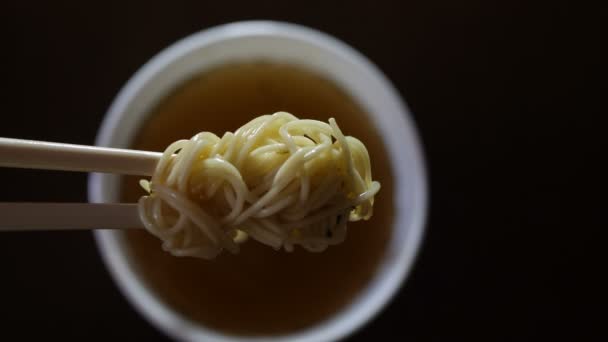 Close-up van instant noedels gele ramen op Chinese eetstokjes — Stockvideo