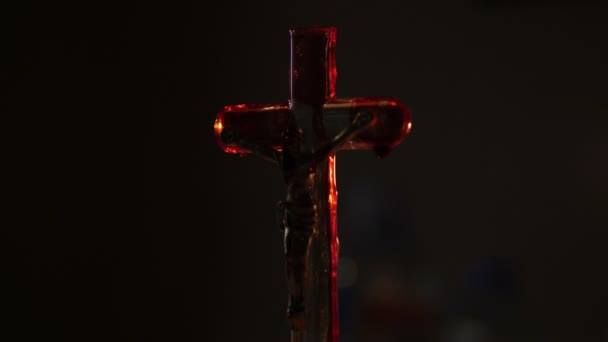 Primer plano de la cruz de Jesús con sangre encendida por una vela. — Vídeos de Stock