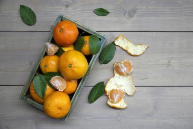 Ahşap kutu yapraklarda ile taze mandarin portakal meyve
