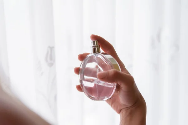 Elegant bride holding in hands a bottle of luxury perfume