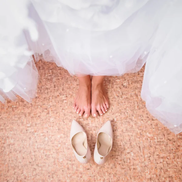 花嫁のウェディング ドレスの下の靴で足 — ストック写真