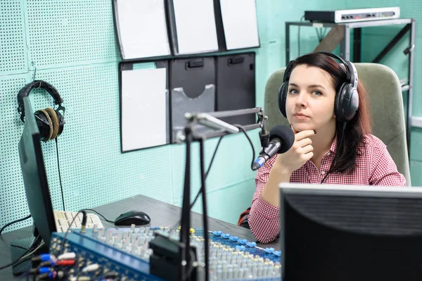 A radio DJ announces news in a radio-studio