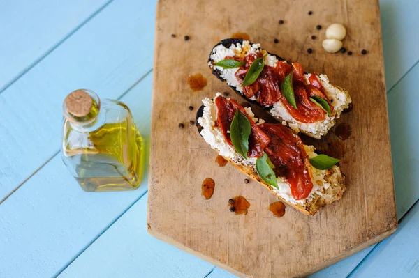 Bruschetta italiana con tomates asados, queso mozzarella y — Foto de Stock