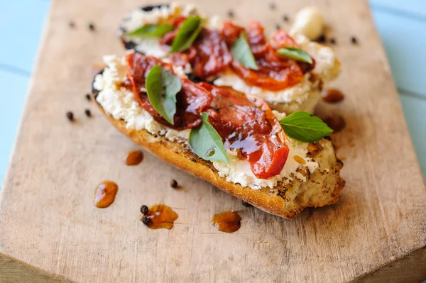 Bruschetta italiana com tomate torrado, queijo mussarela e Imagens De Bancos De Imagens