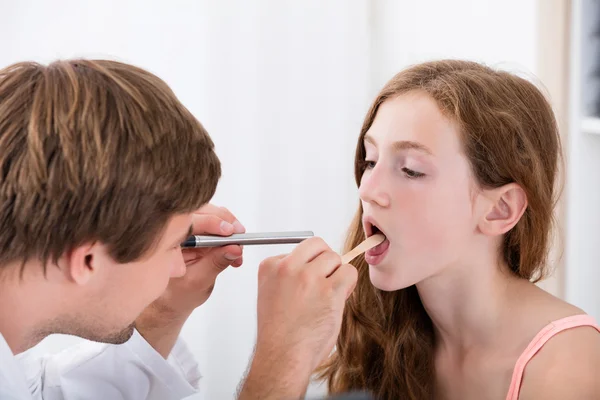 Nahaufnahme eines Arztes, der die Kehle des Mädchens untersucht — Stockfoto