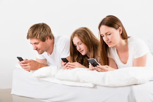 Família usando telefone celular — Fotografia de Stock