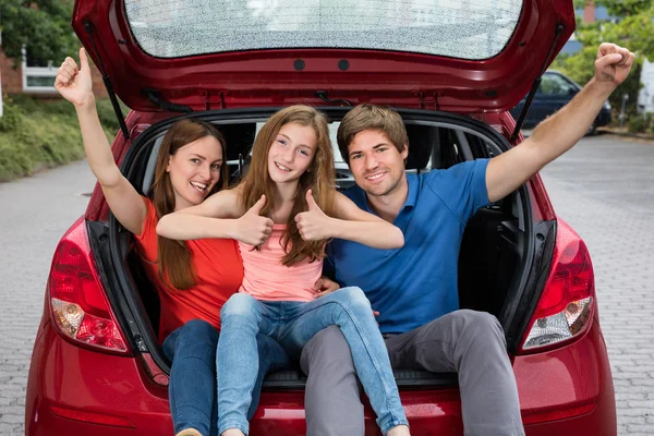 Gelukkige opgewonden paar zitten In auto kofferbak — Stockfoto