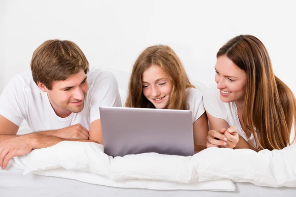 Familia feliz usando el ordenador portátil — Foto de Stock