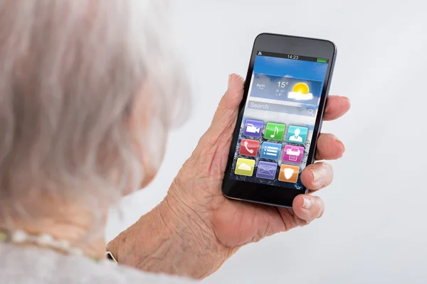Крупный план пожилой женщины с помощью смартфона — стоковое фото