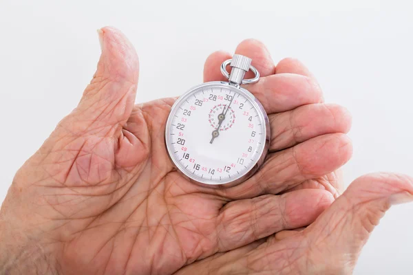 Donna anziana che tiene fermo orologio — Foto Stock
