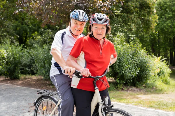 Пара пожилых людей на велосипеде — стоковое фото