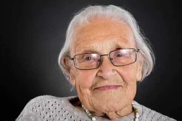 Улыбающаяся пожилая женщина в очках — стоковое фото