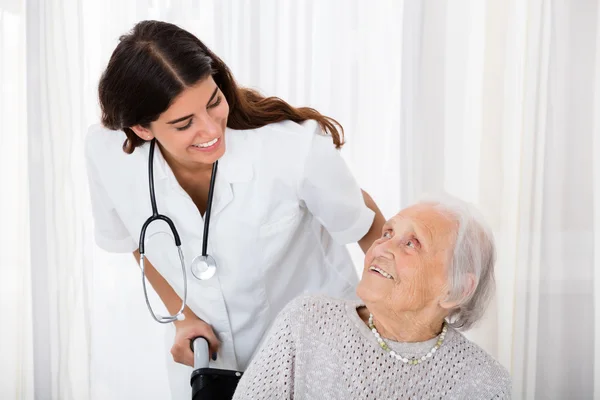 Женщина-врач помогает пожилым пациентам — стоковое фото