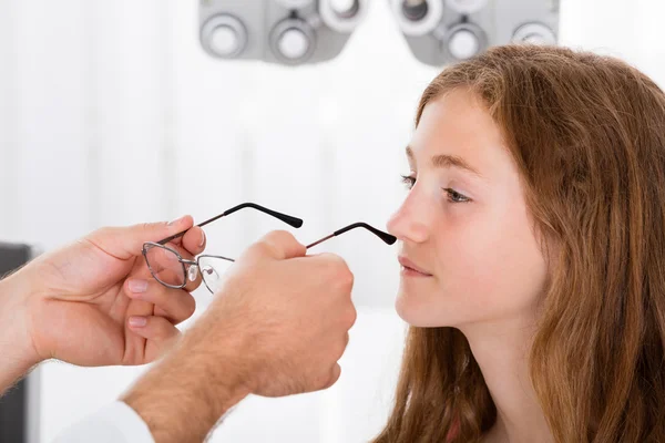 Uma menina de ajuda óptica com óculos novos — Fotografia de Stock