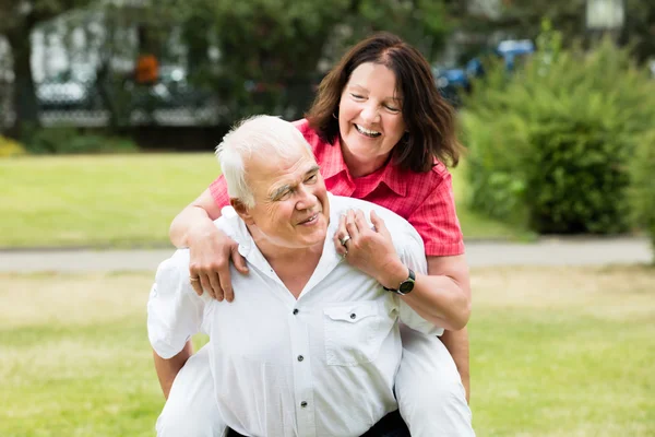 Senior l'homme piggyback son femme — Photo