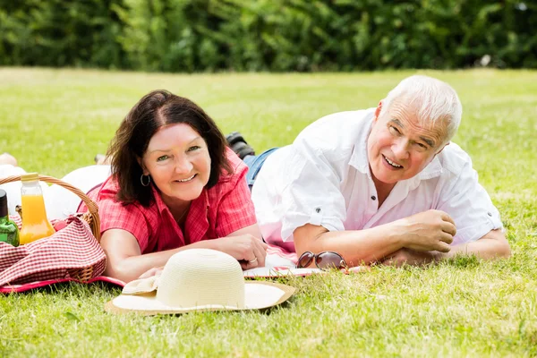 Couple souriant couché sur l'herbe — Photo