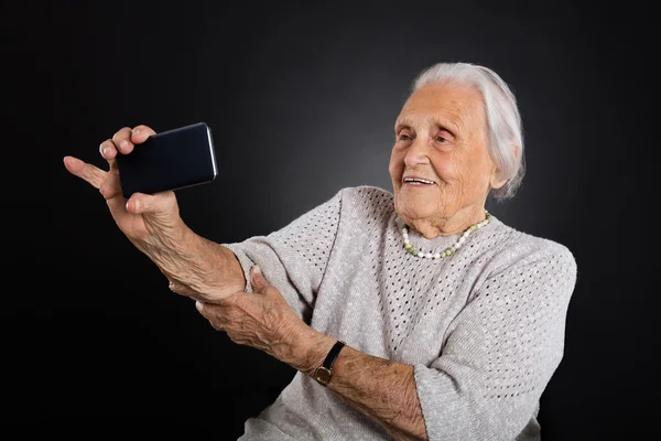 Пожилая женщина делает селфи — стоковое фото