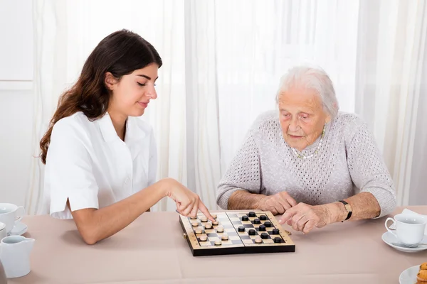 Игра двух женщин в шашки — стоковое фото