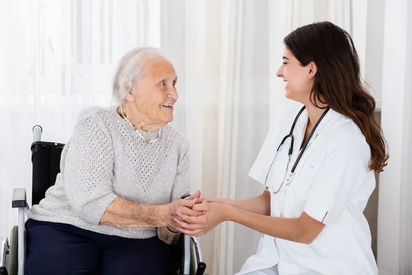 Medico femminile Consolante handicappato Paziente anziano — Foto Stock