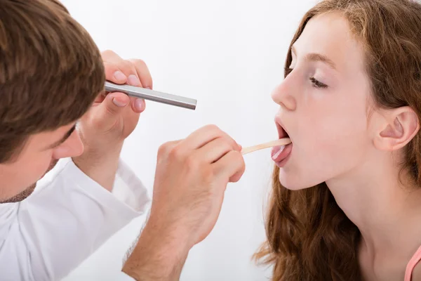 Primo piano del medico esaminando la gola della ragazza — Foto Stock